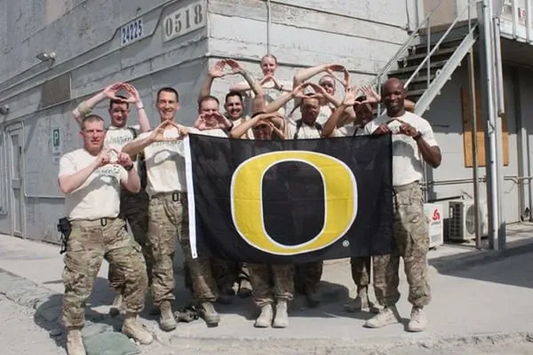 Members of University of Oregon Veterans Network holding university flag